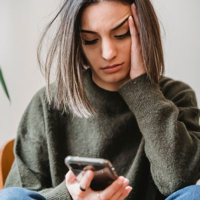 Woman looking concerned while checking her phone