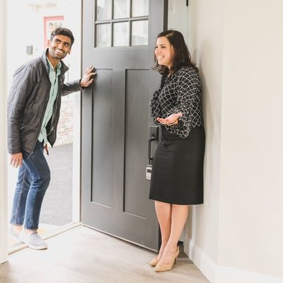 Leasing agent greeting a prospective tenant at the door