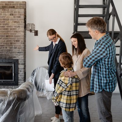 Real estate agent showing a living room to a family